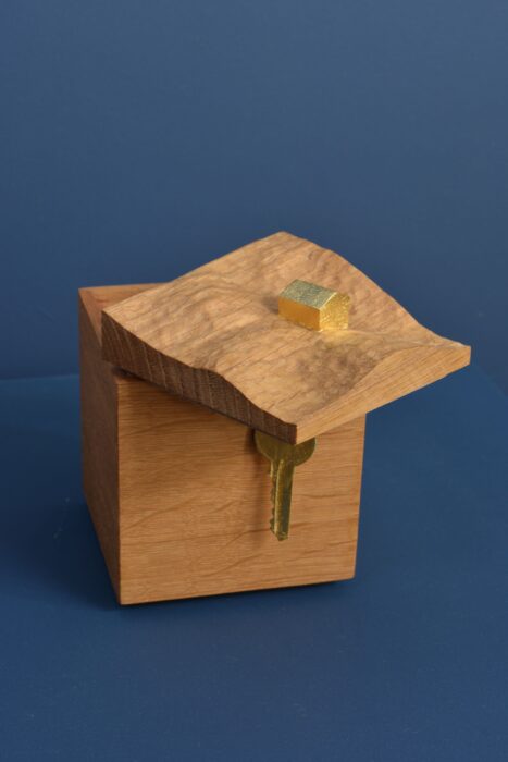 Handcrafted oak luxury box with a small gilded house on top and a golden key secured inside with a magnet.