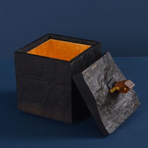 Hand-carved black oak box with zebrano wood house featuring gilded accents on a tilted lid, gold leaf interior and magnetized key, titled Black Storm