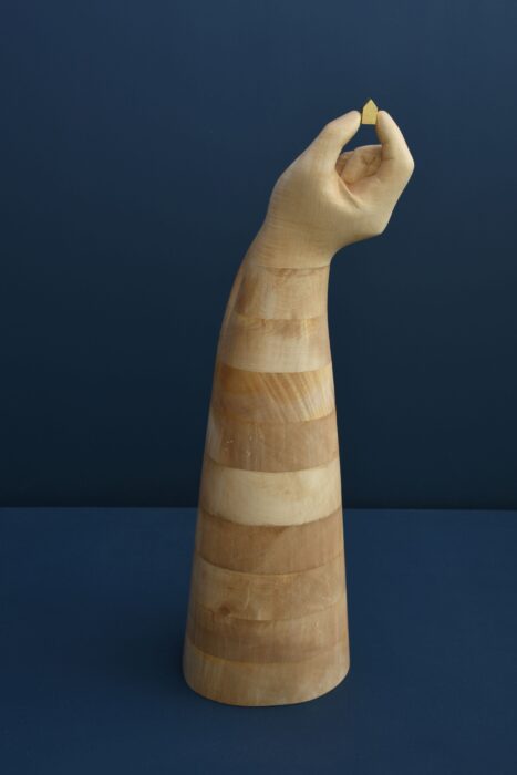 Wooden sculpture of big hand holding a small house 3